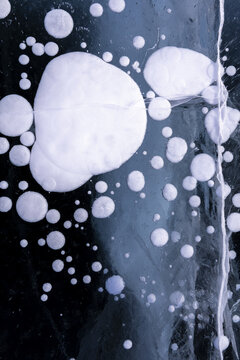 View of methane bubbles trapped in the thick, transparent ice of Lake Baikal, Russia.