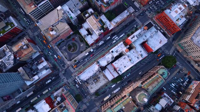 Manhattan streets form a diagonal grid around city blocks. An overhead view reveals white rooftops and crosswalks beside a church with green roof sections.