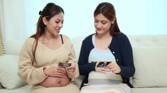 Two new mothers share positive perspectives as they gaze at an ultrasound image of a baby with joy both express their love and celebrate the approaching due date together.
