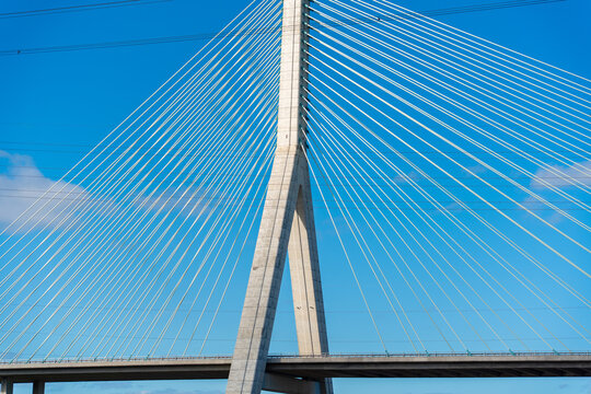 View of the Flintshire Bridge with its prominent concrete pylon and radiating steel cables against a clear blue sky in Deeside, Wales, United Kingdom.