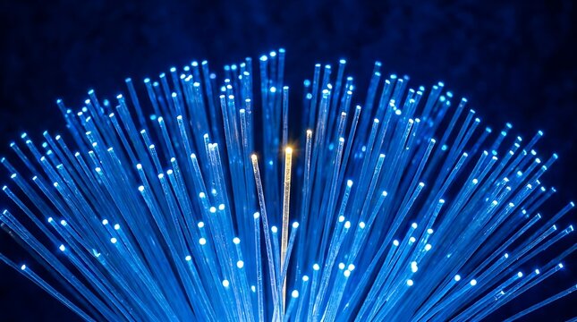 Close up of illuminated fiber optic strands emitting blue and yellow light against dark background
