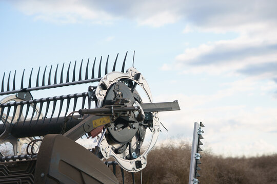 View of a futuristic combine harvester header mechanism during a canola harvest in a field under a cloudy sky in Cherkasy, Cherkasy Oblast, Ukraine.
