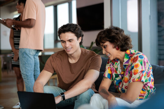 Coworkers collaborate on a laptop during a break