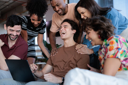 A diverse group of friends celebrate a friend's win