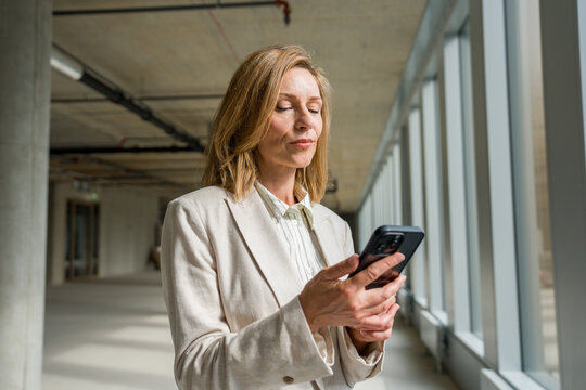 Businesswoman Using Cellphone At Construction Site