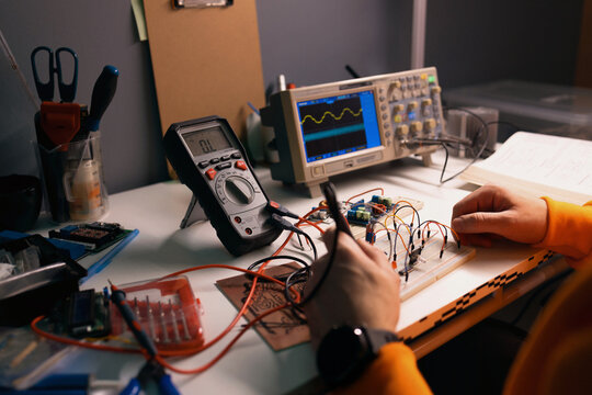 Electronics Engineer Testing Circuit On Breadboard With Multimeter