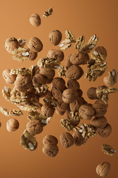 Flying Walnuts and Kernels on Warm Brown Background