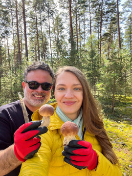 Couple Collects Mushrooms in Forest During Sunny Day