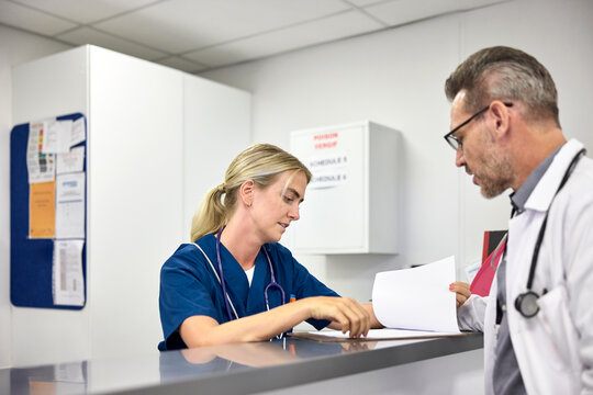 A doctor speaks with a nurse at the hospital.
