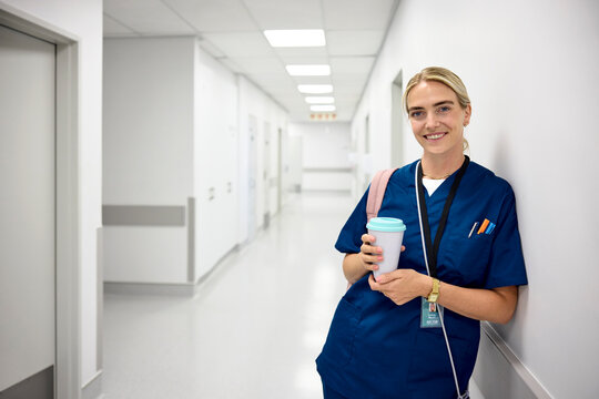 Portrait of Smiling Doctor in Scrubs With take away Coffee