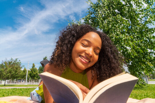 woman shopper reading book in sunny park