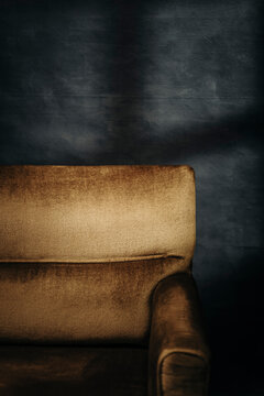 golden Chair Against a Dark Blue Wall With Shadow Patterns