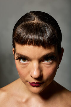 Woman with short hair and bold makeup in a studio setting