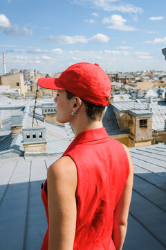 View From a Rooftop With a Woman in a Red Outfit and Cap