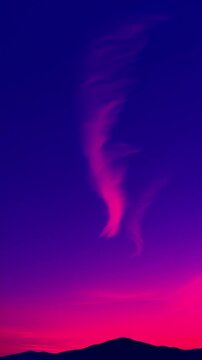 Dusk clouds drifting through a purple to navy sky vertical video