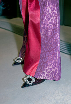 Close-up of black patent pointy toe heels and leopard print trousers