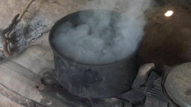 traditional country kitchen using a wood burning stove with a black pot on top