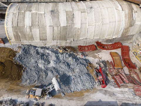 Aerial view of a construction site featuring a large tunnel formwork segment, a pile of excavated soil, and a bulldozer operating on the ground in Istanbul, Istanbul, Turkiye.