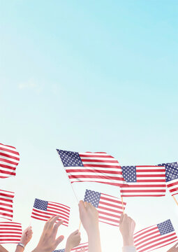 Hands waving American flags against a bright blue sky at a patriotic celebration