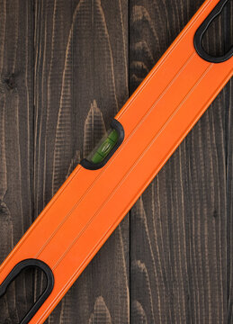 op view layout of a professional bubble level instrument on a textured wood surface. Minimalist backdrop setup with blank space for text, ideal for renovation banner design.