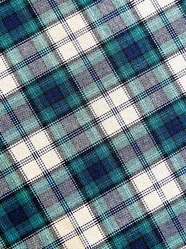 Turquoise and blue plaid fabric texture, classic Scottish tartan pattern background, checkered cotton cloth close up