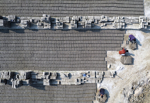 Aerial view of workers arranging rows of drying bricks in a brick field in Gaibandha Sadar Upazila, Rangpur Division, Bangladesh.