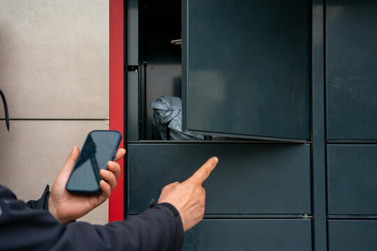 Person Using Smartphone to Open Automated Parcel Locker Door for Contactless Package Collection