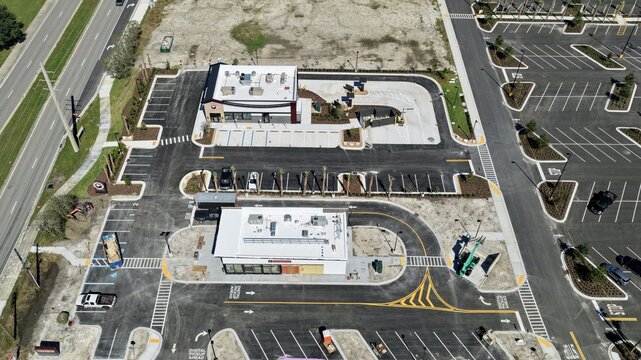 Aerial view of a commercial development with drive-thru lanes, parking lots, and buildings at Foundry Lane and International Golf Parkway in World Golf Village, Florida, United States.