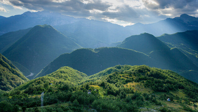 Aerial view of sunbeams over the green mountain valleys of Durmitor with lush forests and rugged peaks in Zabljak, Zabljak Municipality, Montenegro.