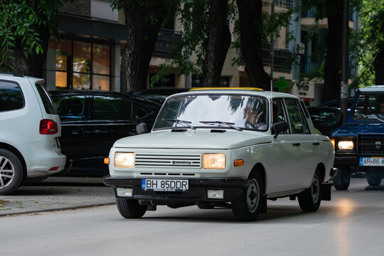 White Wartburg 353 W classic East German sedan with headlights turned on driving along city street  in  Subotica, Serbia - June 6, 2026
