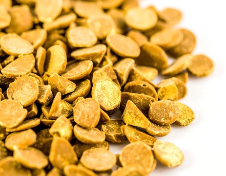 Close view of dried golden flakes on white background