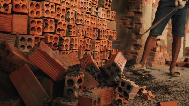 Hollow bricks stacked beside a worker in Mang Thit, Vietnam