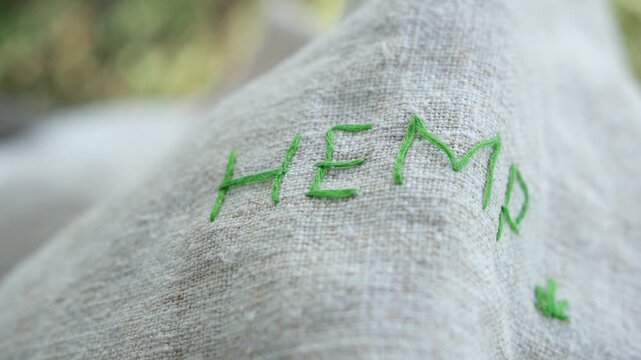 Hemp fabric or hemp canvas. The green word hemp. Environmentally friendly textile. Shallow depth of field.