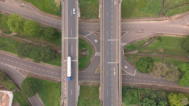 Aerial view of Rodovia Anhanguera highway interchange with a truck driving on the road, surrounded by green grass and trees in Araras, Sao Paulo, Brazil.