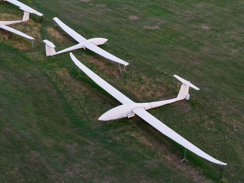 Aerial view of white gliders parked on a grassy airfield in the United Kingdom.
