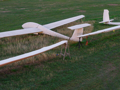 Aerial view of gliders parked on a grassy airfield with wings resting on stands in the United Kingdom.