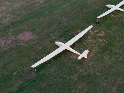Aerial view of two white gliders parked on a grassy airfield in the United Kingdom.