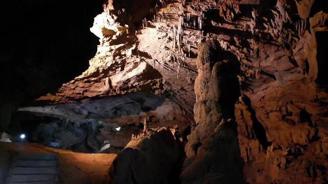 Limestone cave interior with stalactites and dramatic lighting