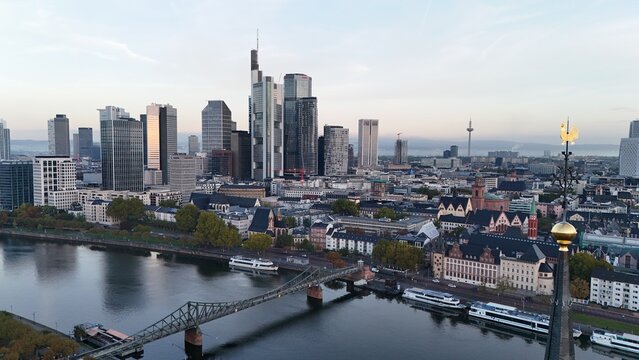 Aerial view of the Frankfurt am Main skyline featuring modern skyscrapers, the Main River, and the historic Eiserner Steg bridge, Frankfurt am Main, Hessen, Germany.