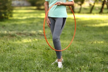 Senior woman with hula hoop in park, closeup. Space for text © New Africa