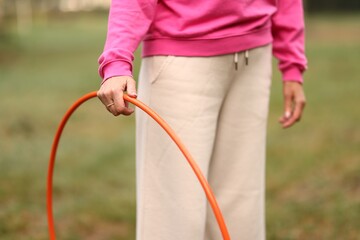 Senior woman exercising with hula hoop outdoors, closeup © New Africa