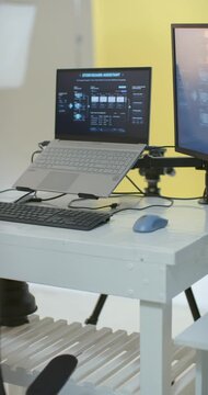 Vertical video: Camera is panning left and backward, revealing laptop on riser to show studio setup