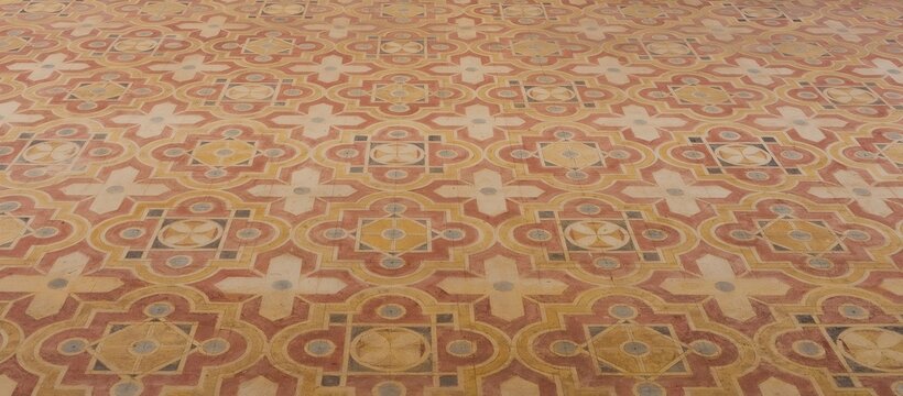 Malaga geometric Moorish pattern in red, yellow, and beige, creating a rich architectural texture and historic background