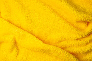 Bright yellow plush blanket fabric background © solidmaks