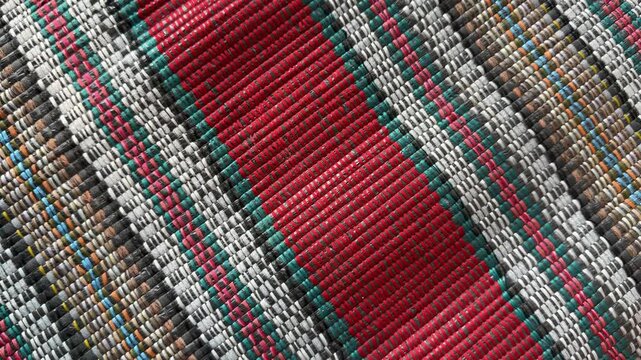 Diagonal interlaced synthetic raffia string mat with shifting sun shadow, woven polypropylene twine texture, 60fps 4K video
