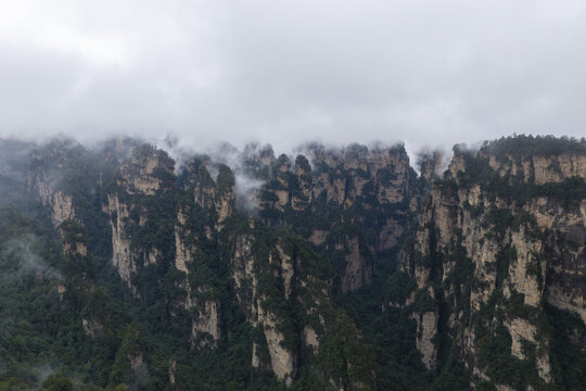 Aerial view of karst mountains with lush green vegetation and mist clinging to the limestone peaks in Guilin, Guangxi, China.