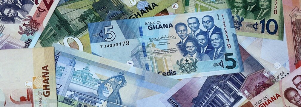Ghanaian cedi money bills in pile on table. Ghana GHS currency banknotes background