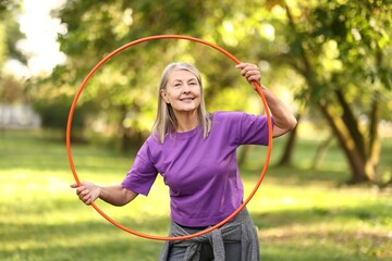 Senior woman with hula hoop in park © New Africa