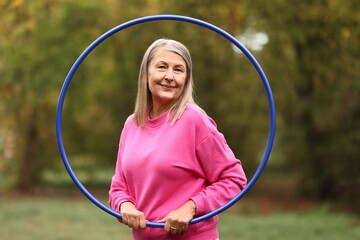 Senior woman with hula hoop in park © New Africa