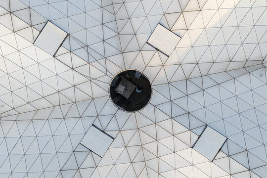 Aerial view of a geometric white roof structure featuring a central circular opening and a complex triangular grid pattern in Guilin, Guangxi, China.